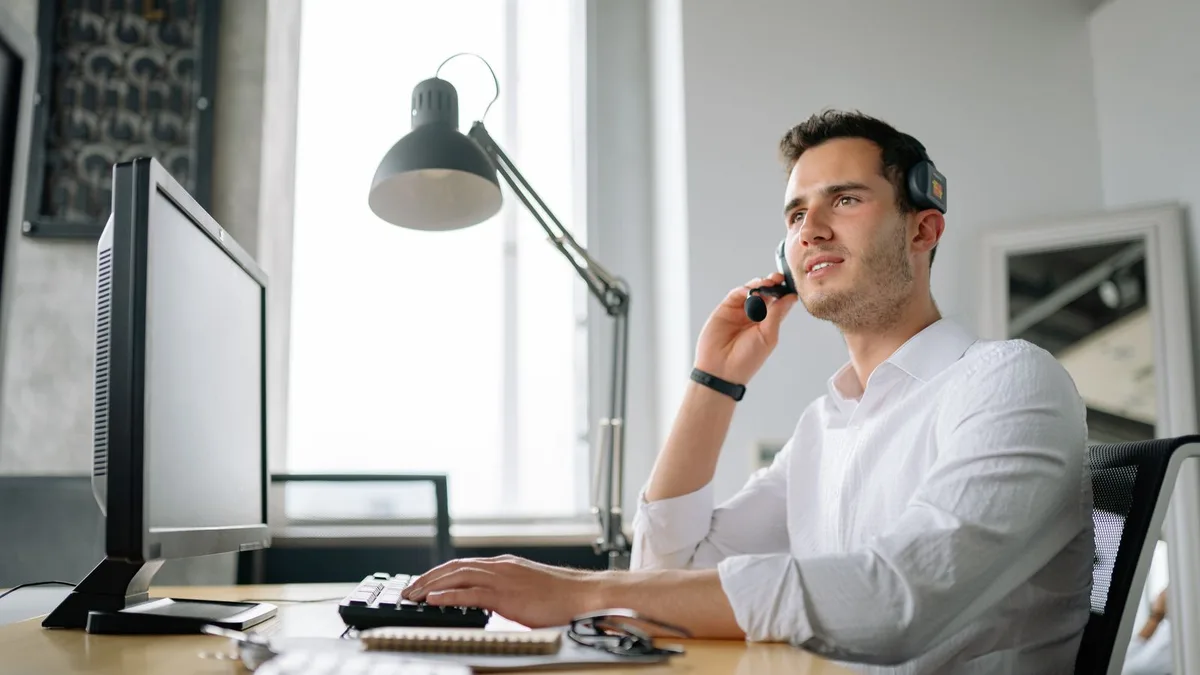 Operadora con auriculares de comunicación y centralita telefónica digital